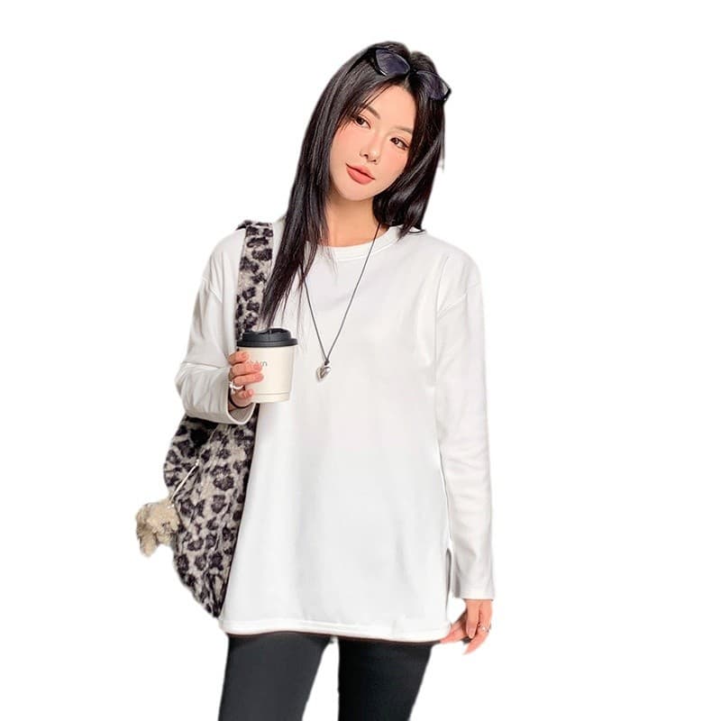 Blusa plus size de manga comprida com fenda curva e modelagem solta.